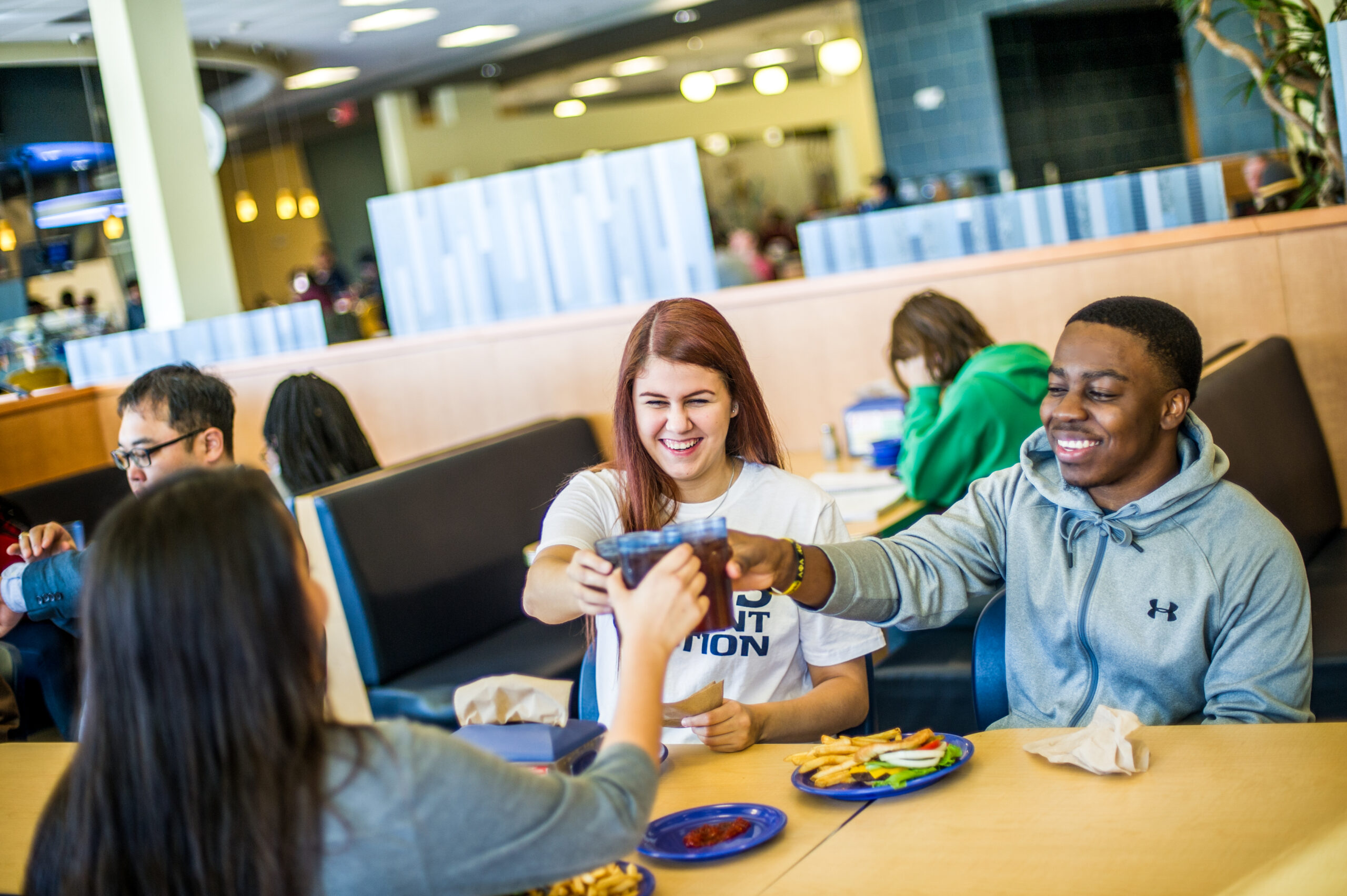 A few students having a pop together in the cafeteria.