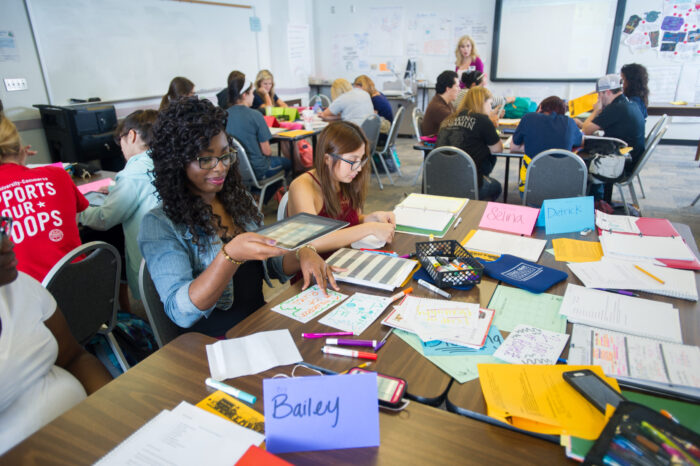 Students sitting a tables during a lecture.