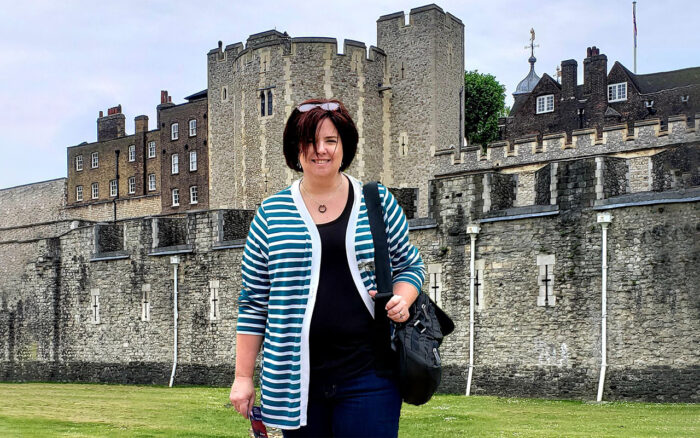 A female in front of a castle.