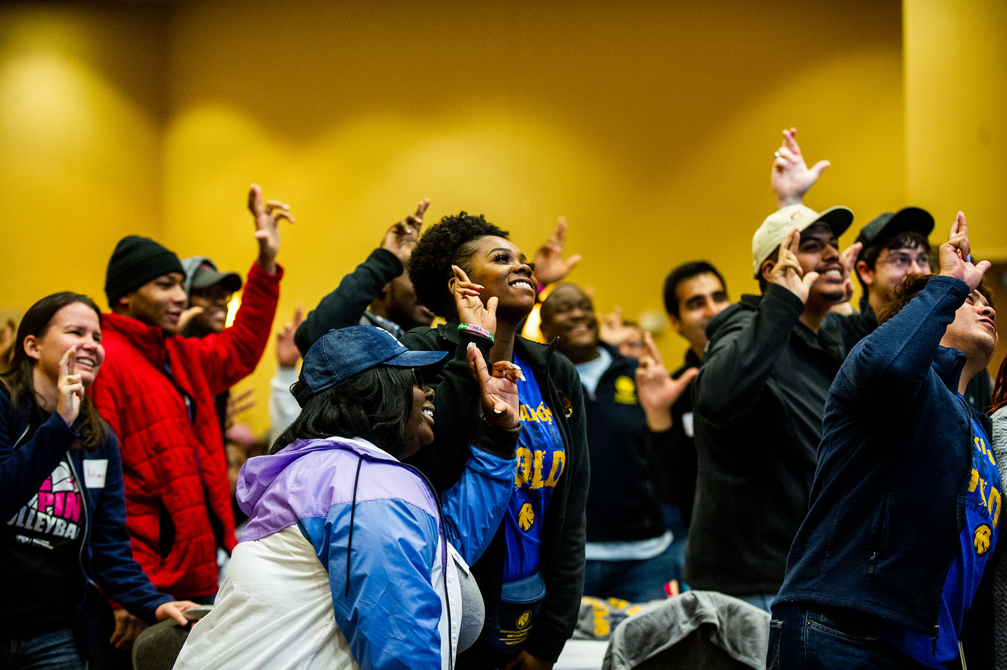 A group of students signing the leo sign in an event.