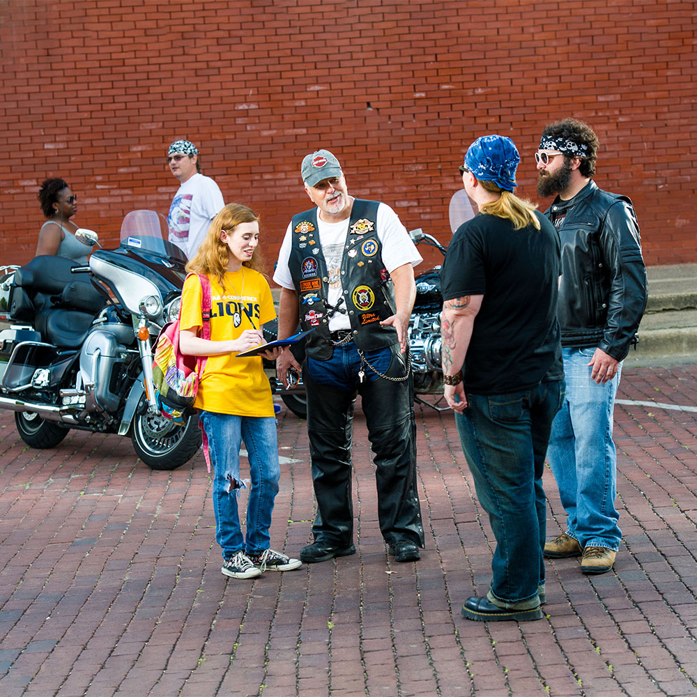 A&M-Commerce student interviewing three bikers.