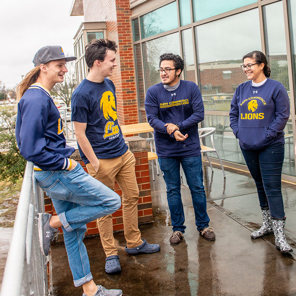 Four student all wearing blue A&M-Commerce shirts.