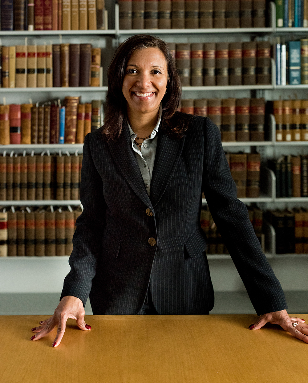 Portrait of professor with bookshelf behind.