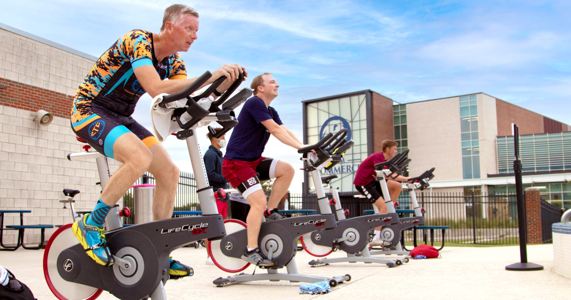 Members during a cycling class by the pool.