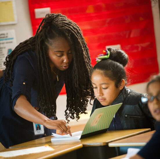 Female teacher instructing young student.