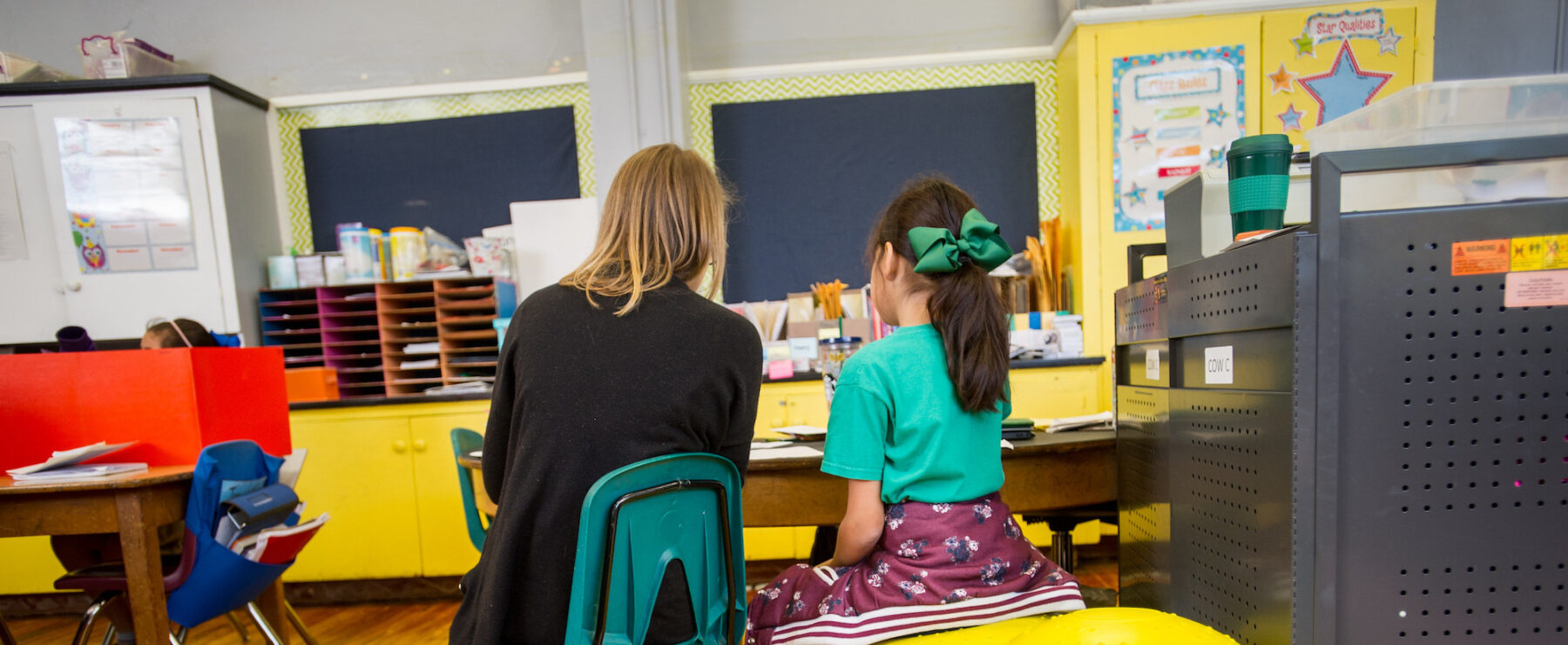 Teacher in a classroom with a young student.