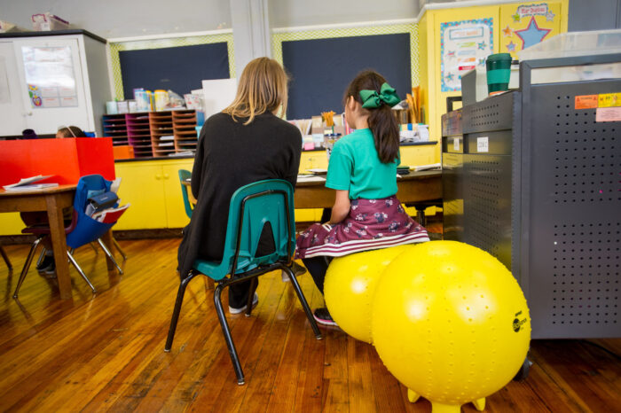 Teacher in a classroom with a young student.