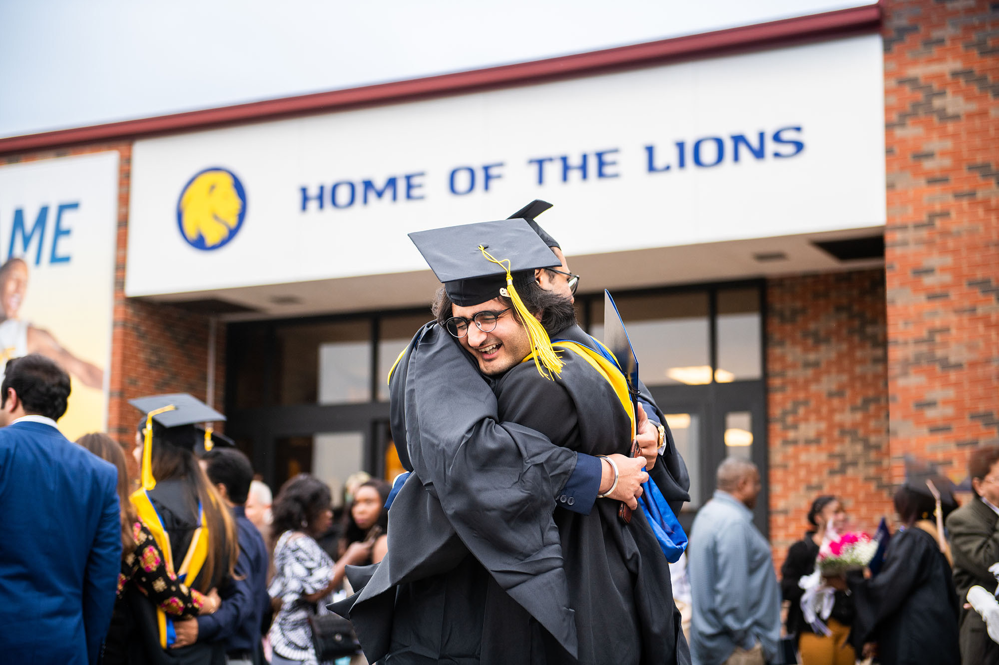 Two students hugging each other after graduation.