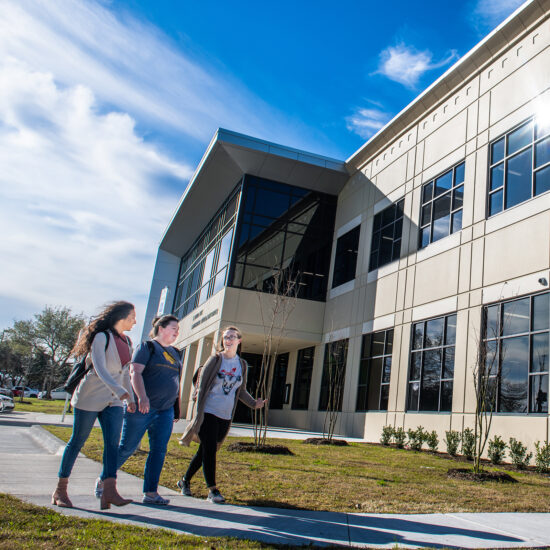 Three students walking on the mesquite campus.