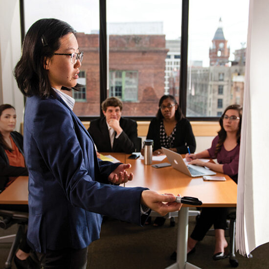 woman in professional attire speaking to college students