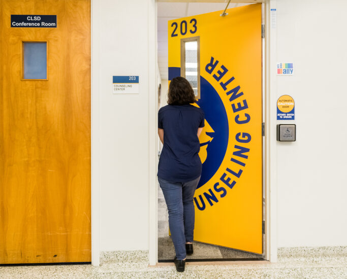 Student entering the door to access the counseling center on campus.