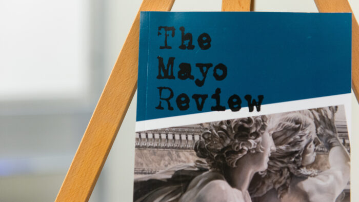 Book on a stand with title "the mayo Review"