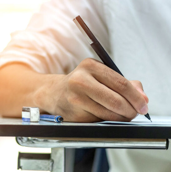 School exam student's taking educational admission test in class, thinking hard, writing answer in university classroom, education and world literacy day concept