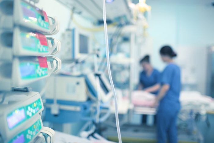 Medical professionals working while surrounded by medical instruments.