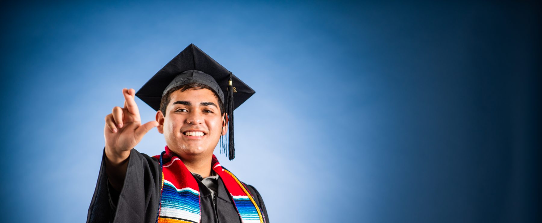 A TAMUC graduate flashes the "L" hand sign to signify Lions