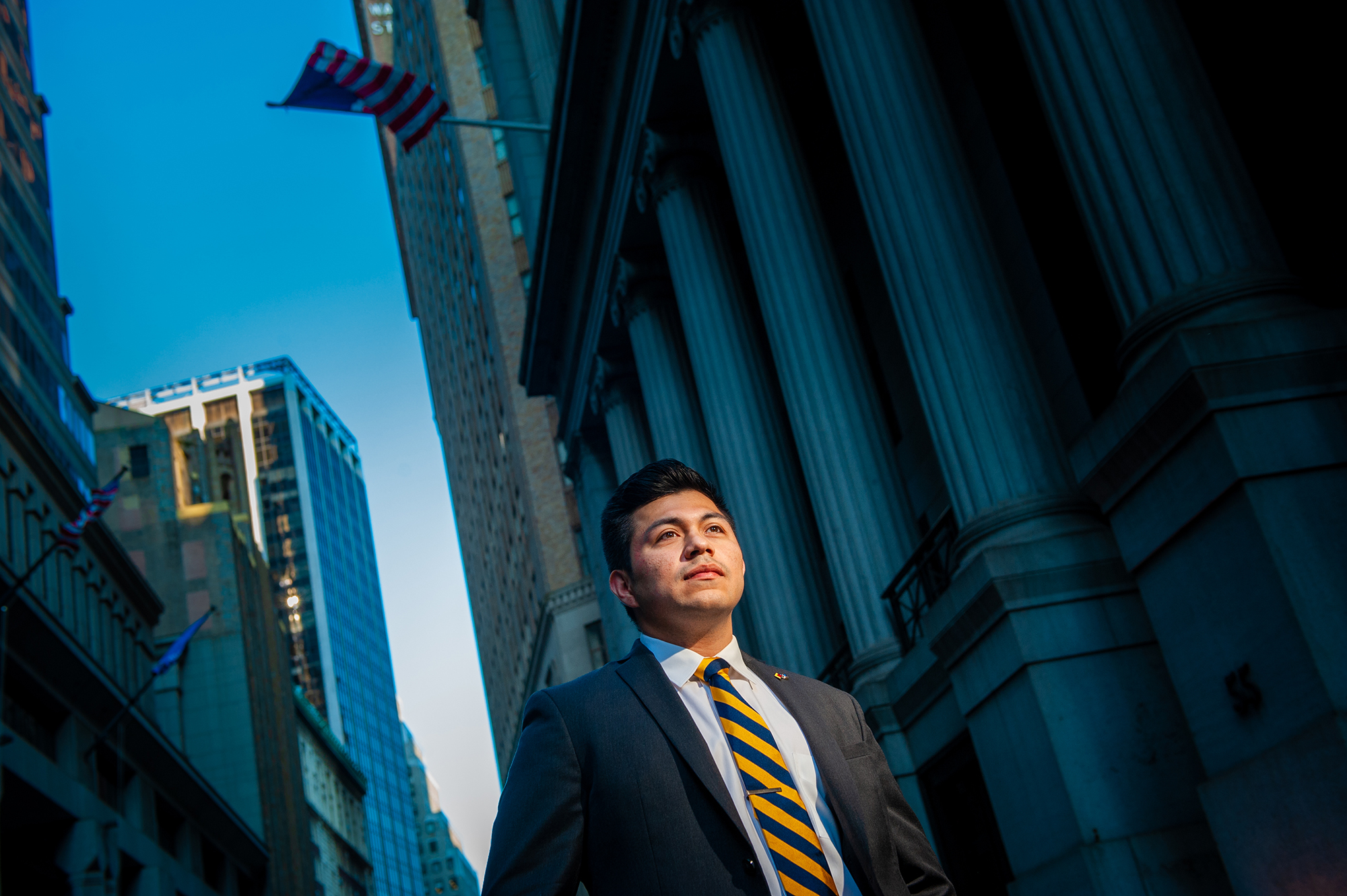 Student in a power suite in front of a building like on Wall Street.