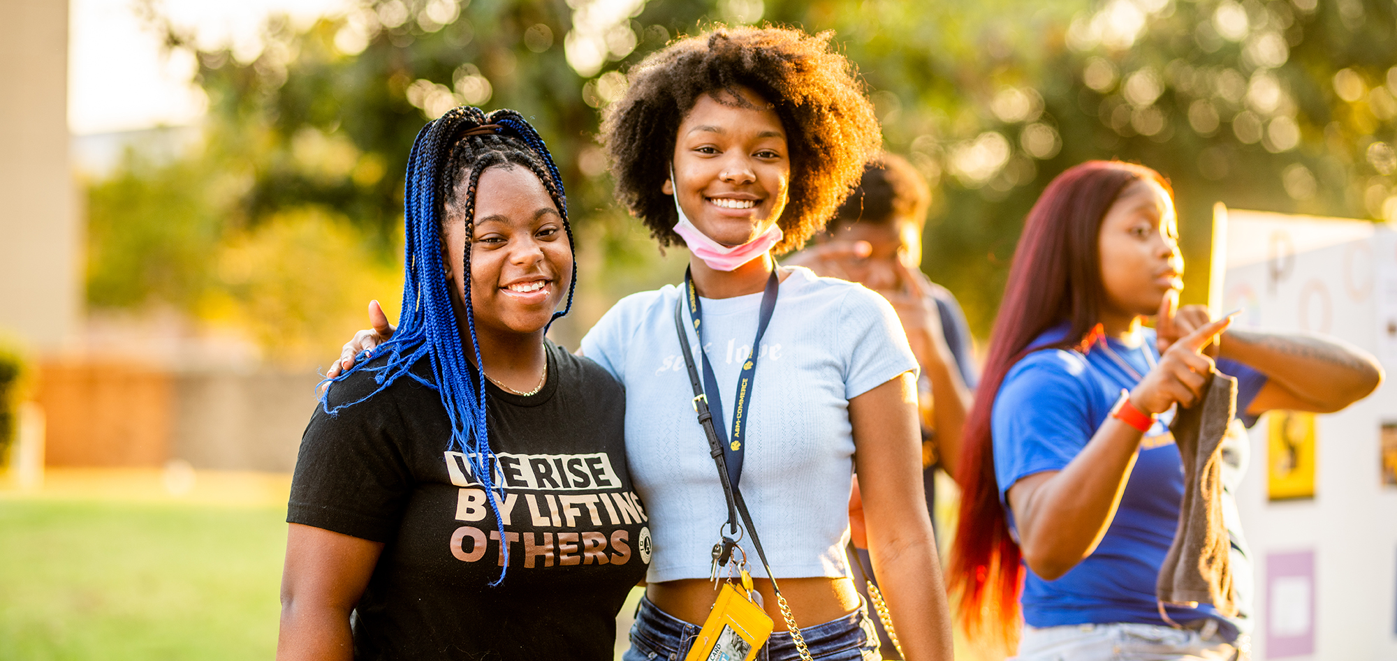 Two students smiling on campus during sunset.