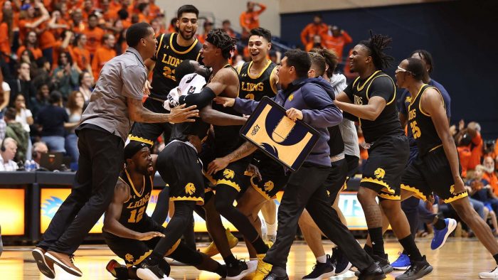 A group of male basketball players come together and celebrate.