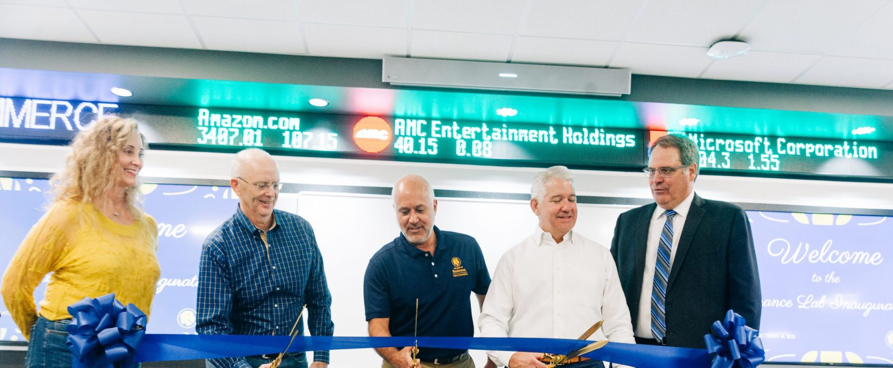 5 Individuals cutting a ribbon