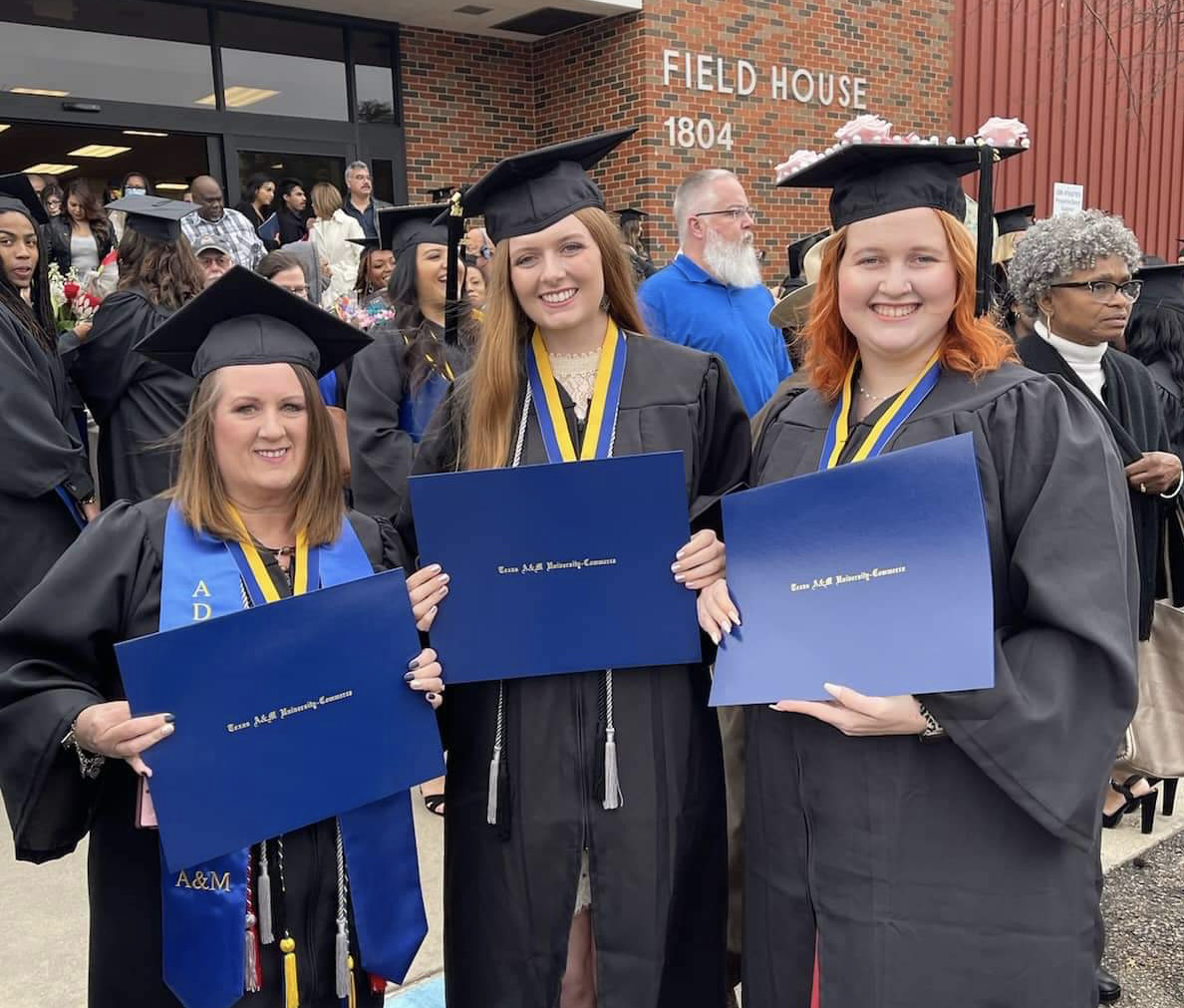 Three TAMUC grads with diplomas