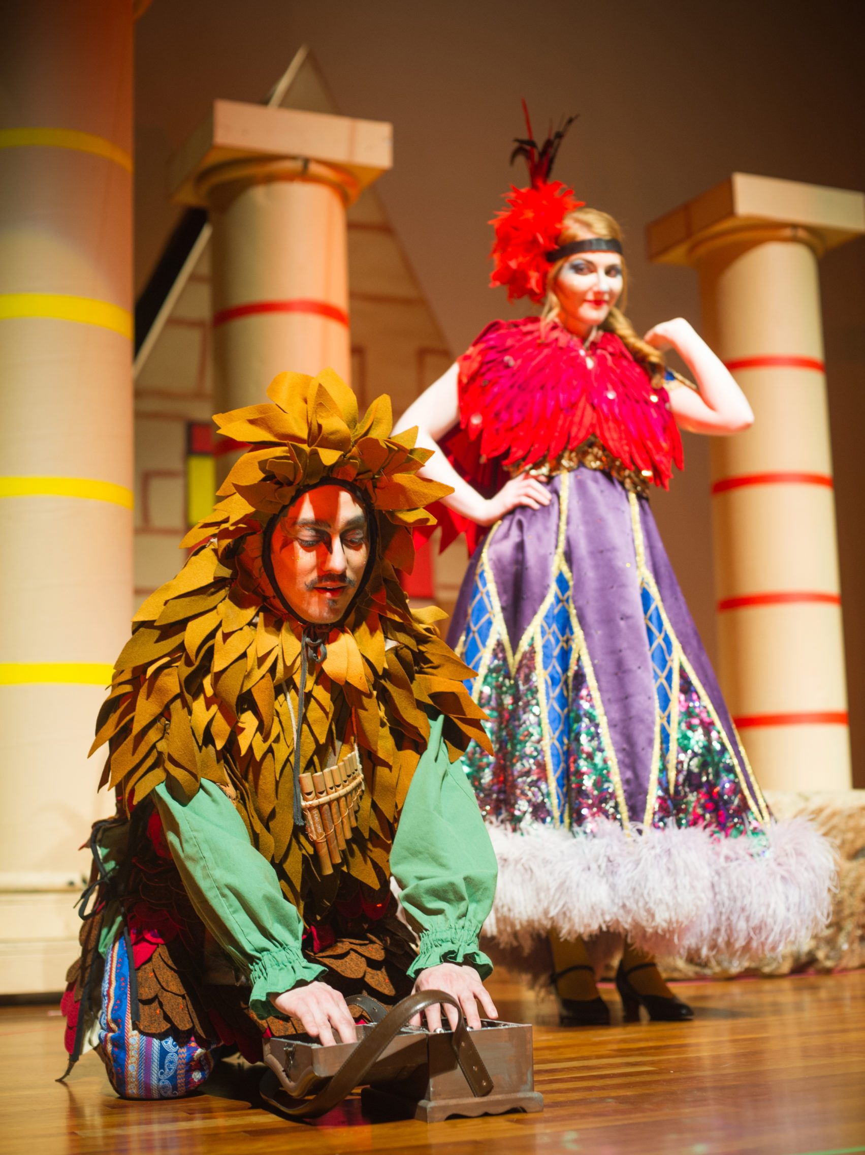 Man and woman wearing costumes on stage of theatrical performance