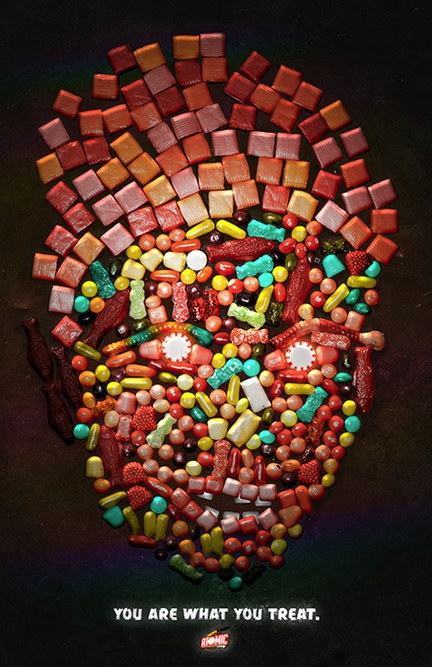 Various candies form the image of a face. "You are what you treat." and atomic candy logo at the bottom