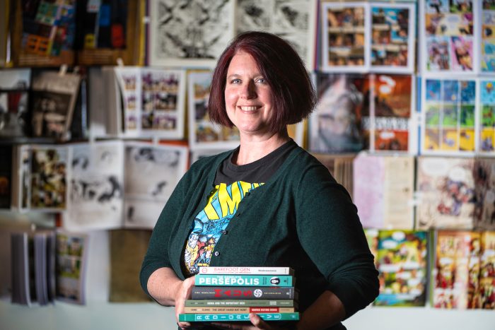 A professor standing with books