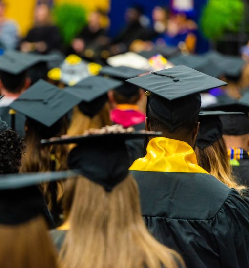 A group of graduating students facing forward with their caps.