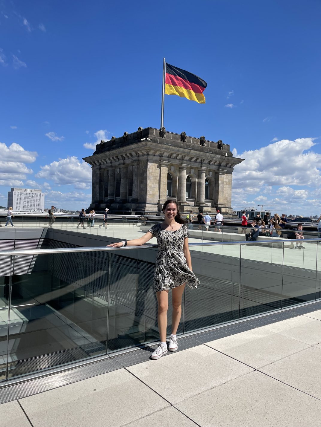 A female student in front of a building with a Germany flag.