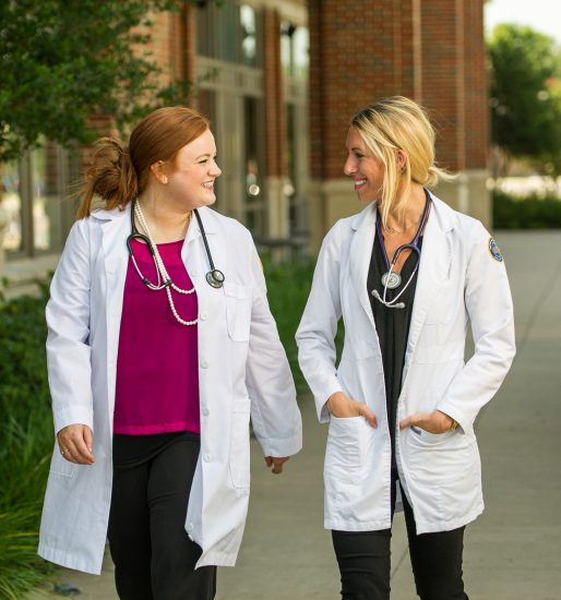 Two nursing student talking to one another.