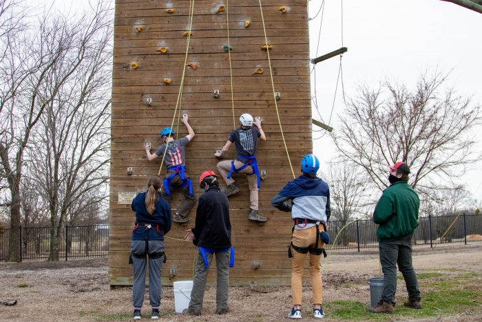 A group of students climbing a rock wall.