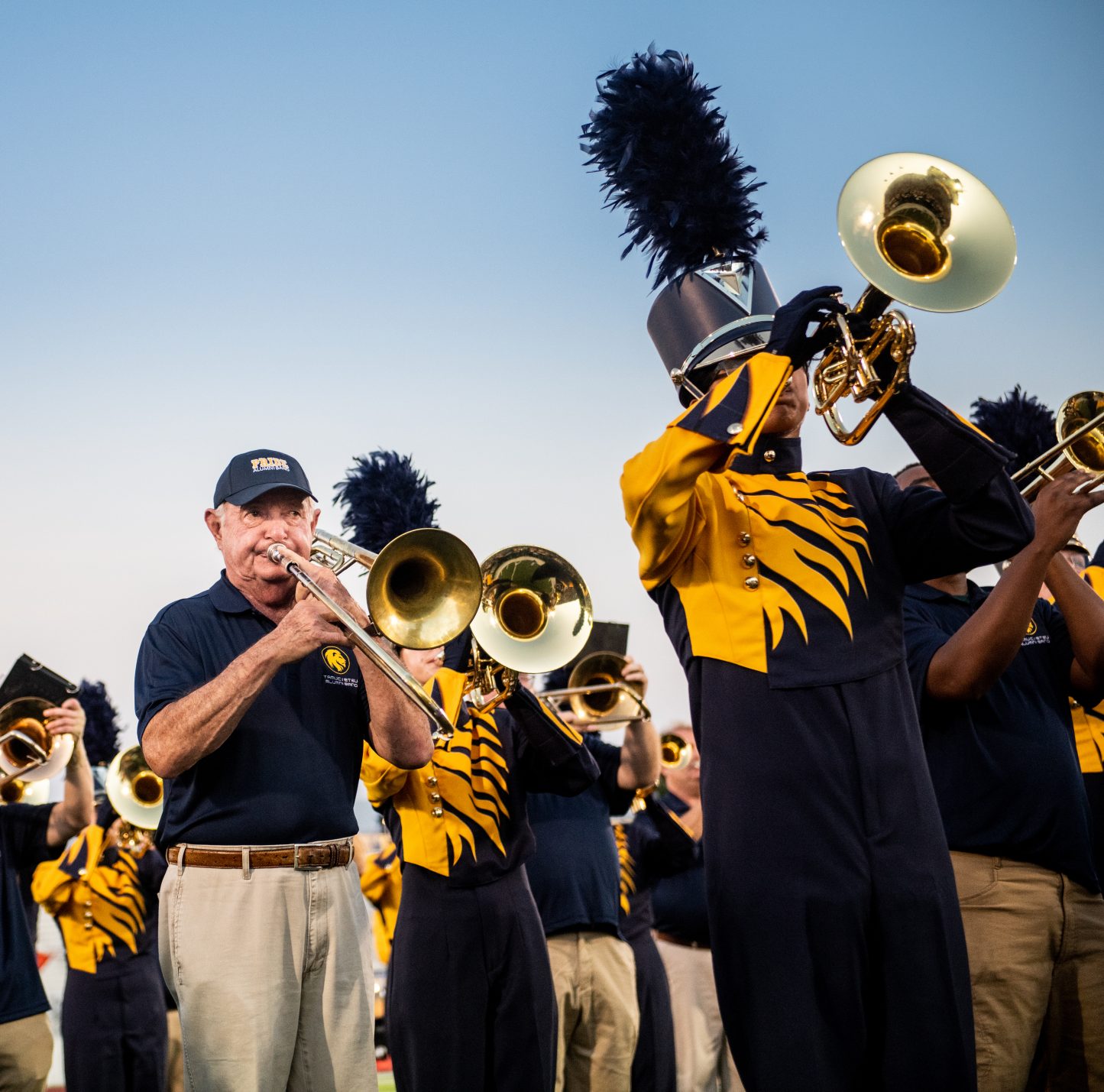 An alumni playing with the current band on trumpets.