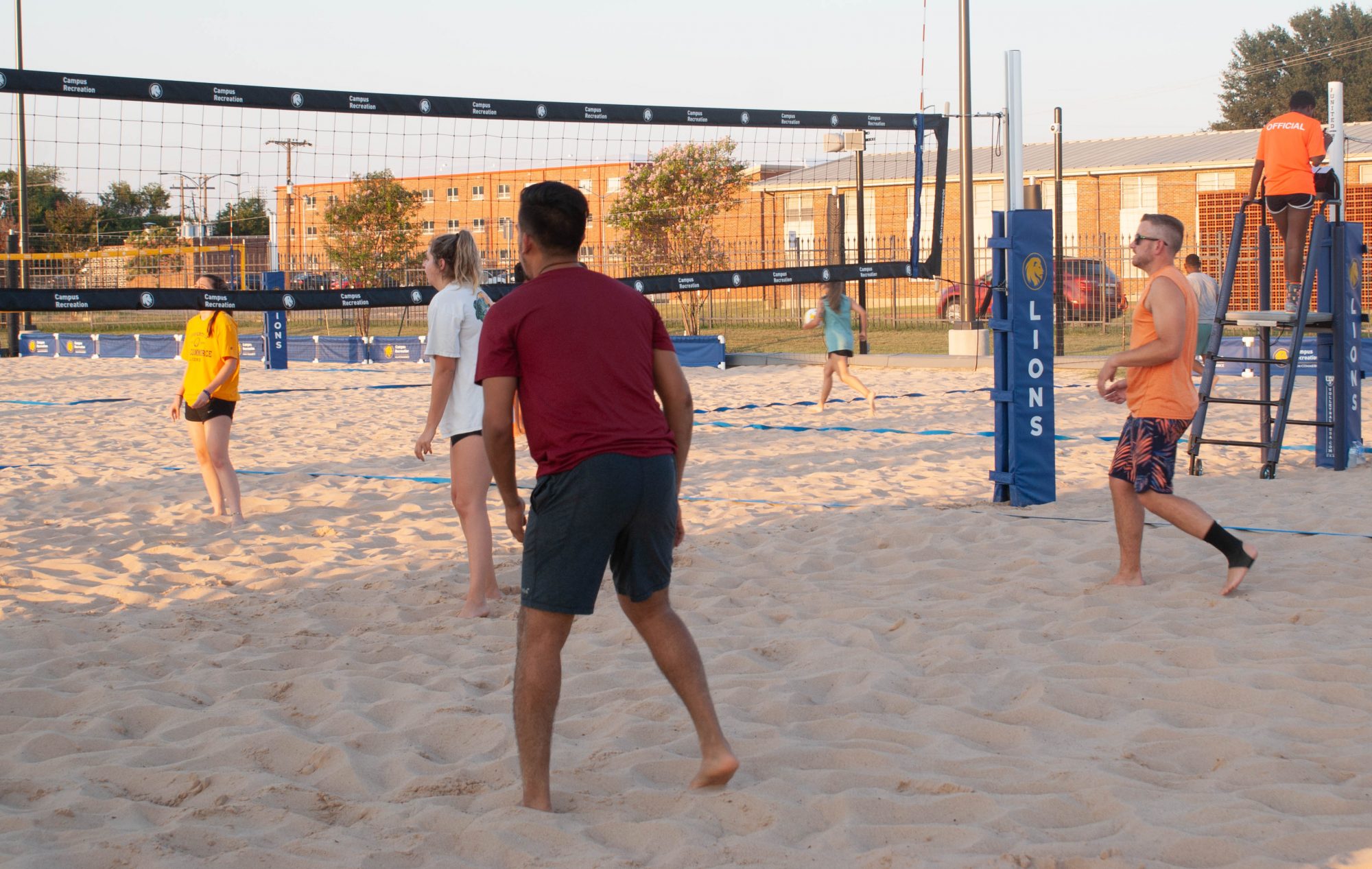 People playing Sand Volleyball on blue net court