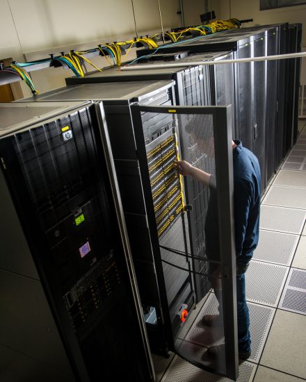 A male student checking computer circuits in a computer room.