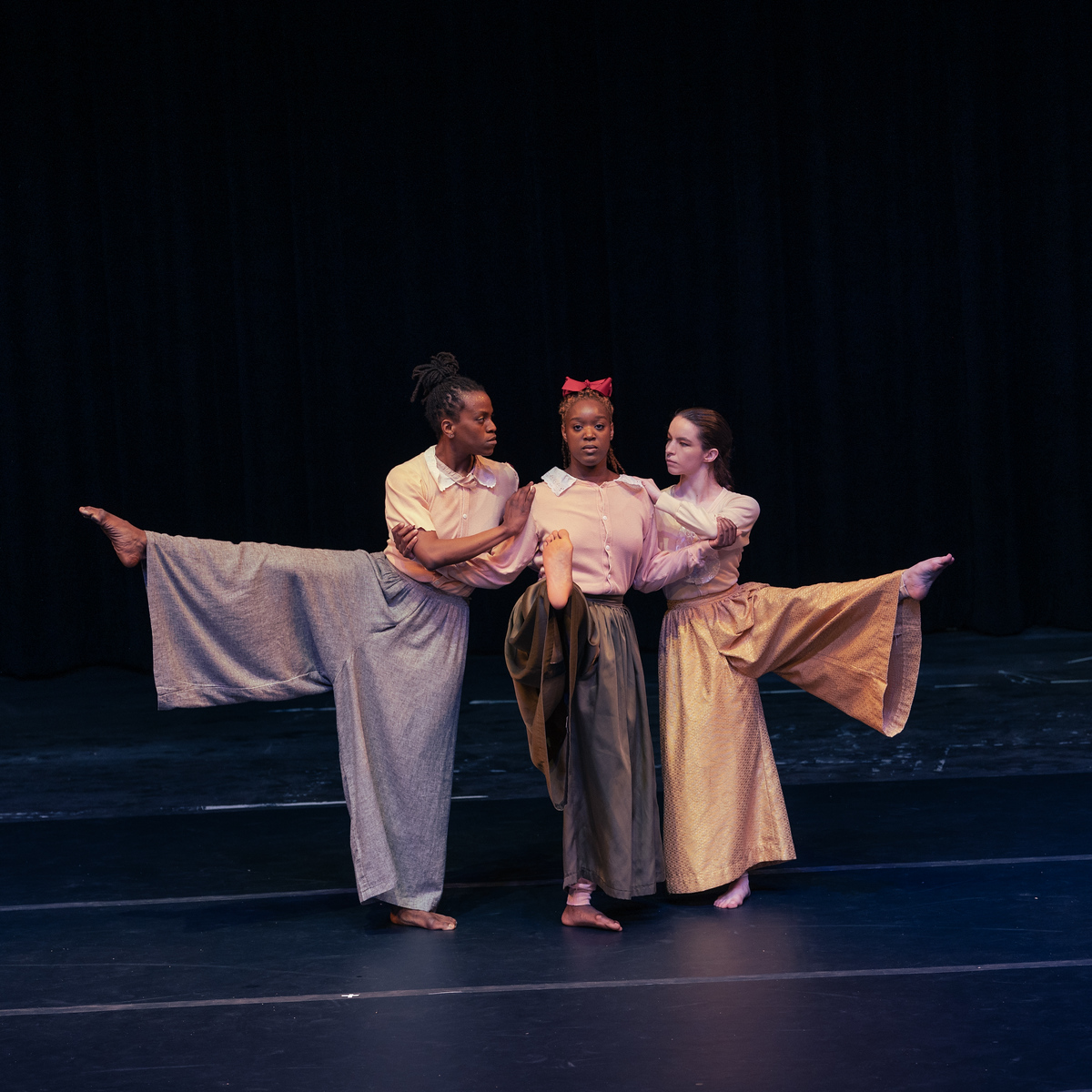 Three performers on stage.