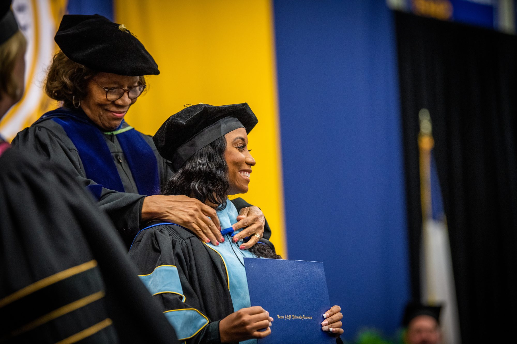 A female student receiving a strip from a faculty memeber.