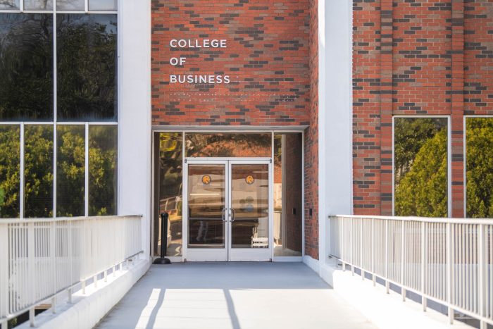 A brick building with the words "College of Business" in metal letters placed above a door.