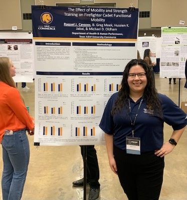 Graduate student stands in front of her poster presentation.