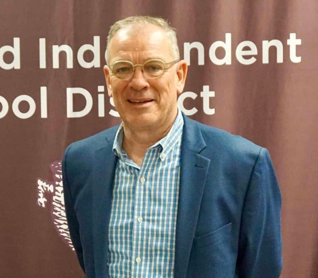 David Maass stands in front of a logo backdrop.