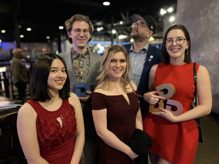 A group of five people pose for a photo.