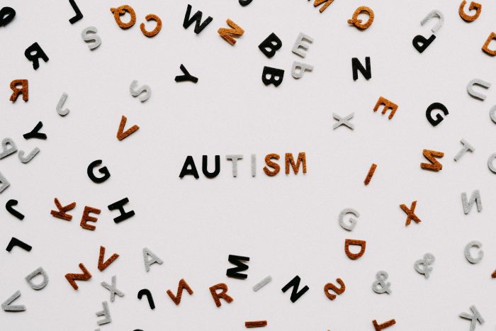 Scrambled colored letters on the periphery and the word "Autism" in the center of the photo