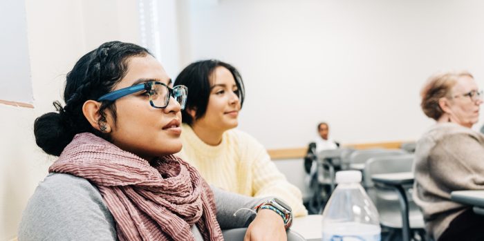 Two female students looking in the same direction in class. 