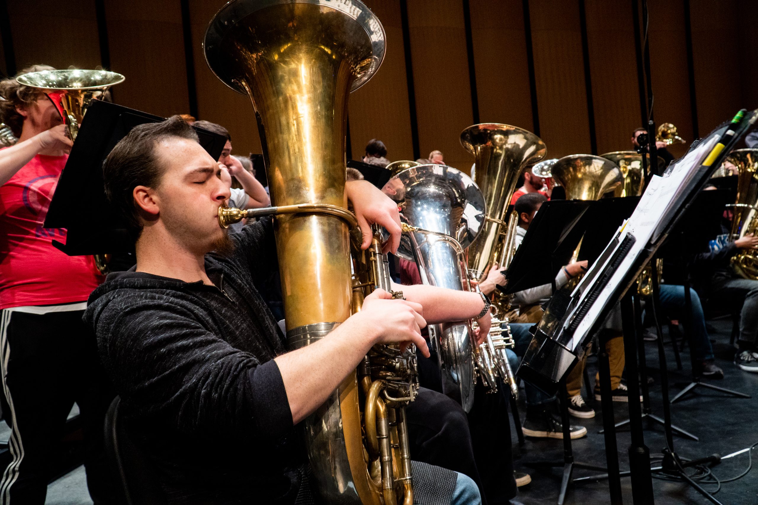A male student playing the tuba.
