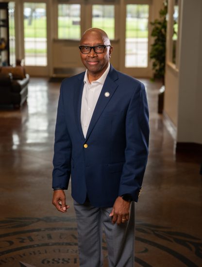 Derryle Peace stands in the foyer of the Alumni Center.