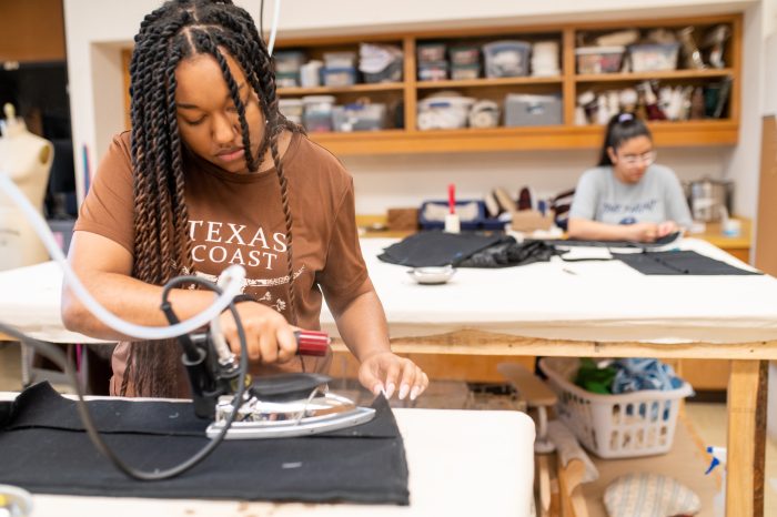 a female student ironing a costume