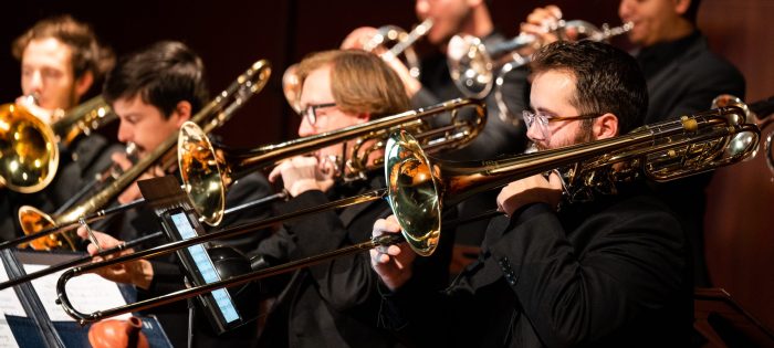 A group of individuals playing the trombone.