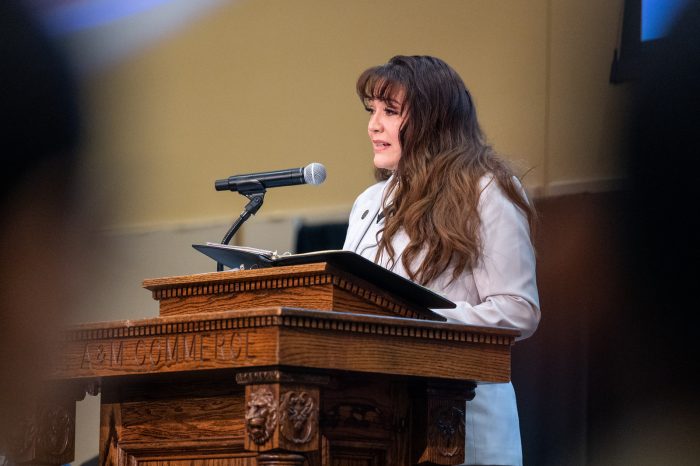 A person standing at a podium with a microphone