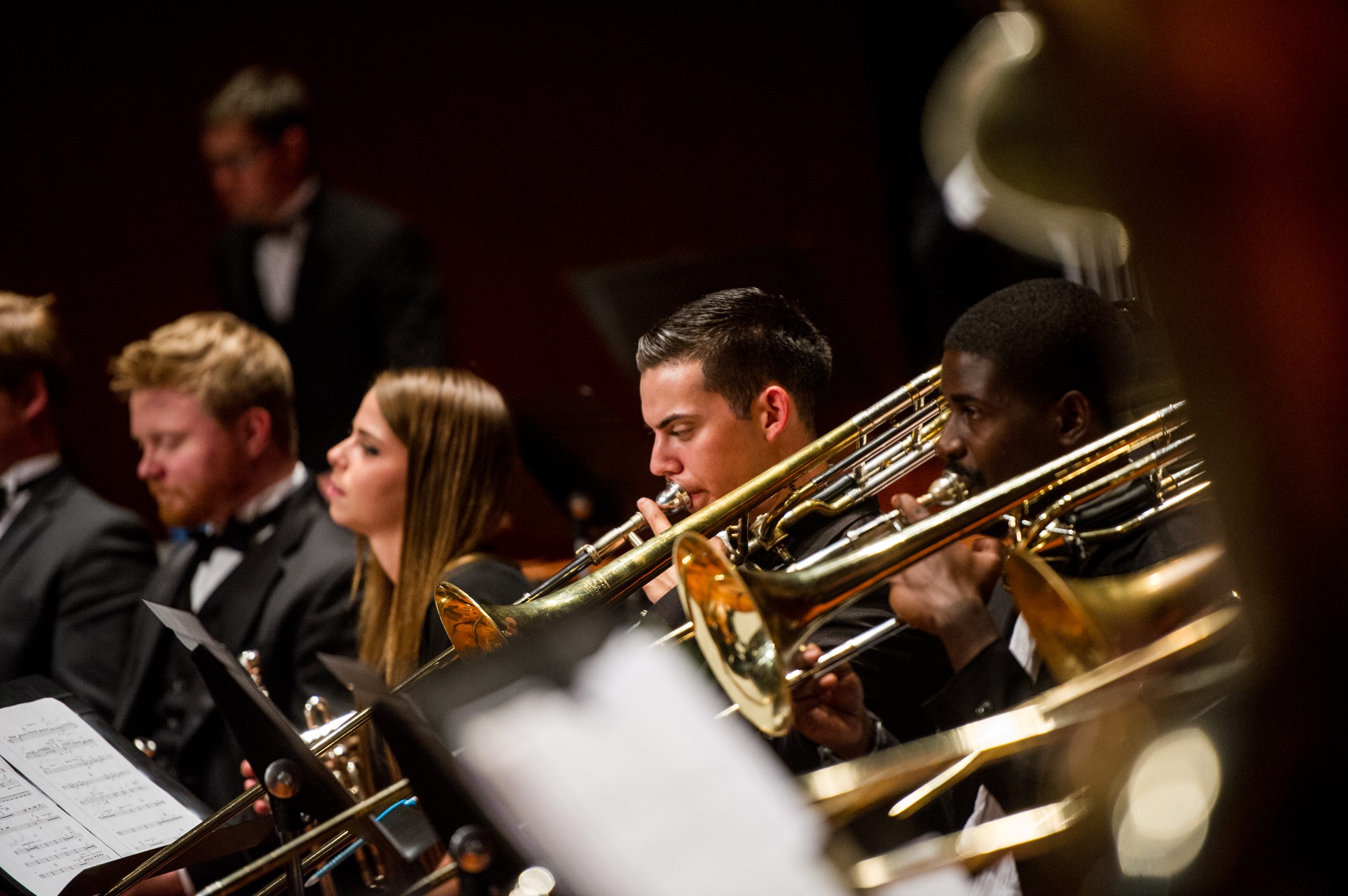 Three individual playing the trombone.