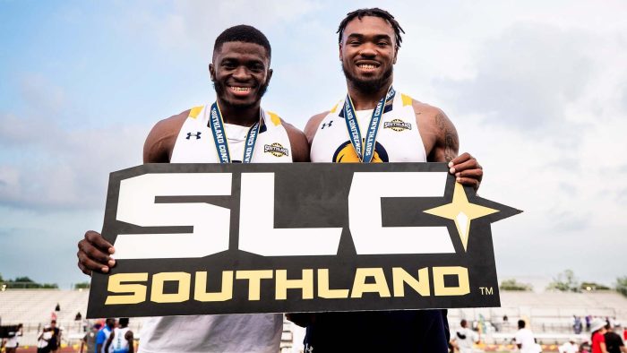 Two athletes hold "SLC Southland" sign.