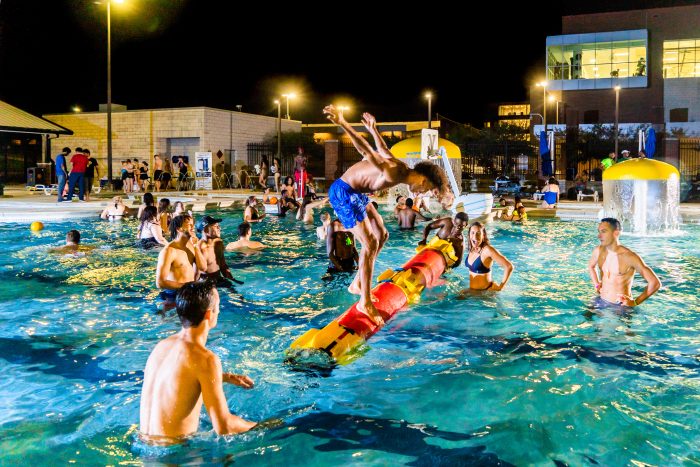 Group of students in swimming pool at night